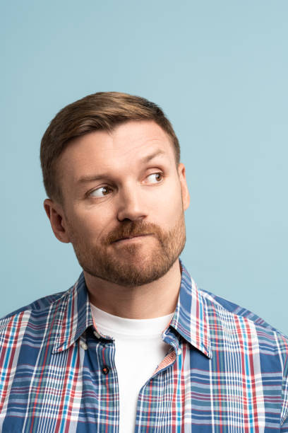 istock Pensive middle aged man pursing lips look in the upper right corner, makes choice, on copy space. 1711126744