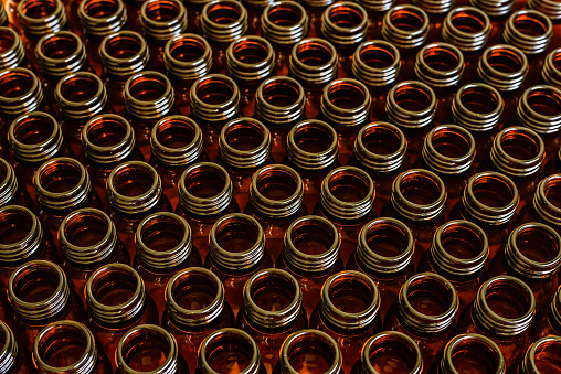 Many glass jars for empty medicines assorted in a row, chemical pharmaceutical industry concept.