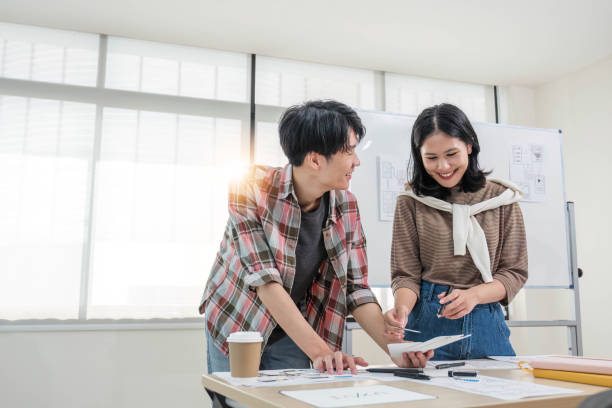 istock A smart and handsome young Asian male website developer is talking and planning a new project with a female colleague in the office. UI, UX, Tech Startup 1711136149