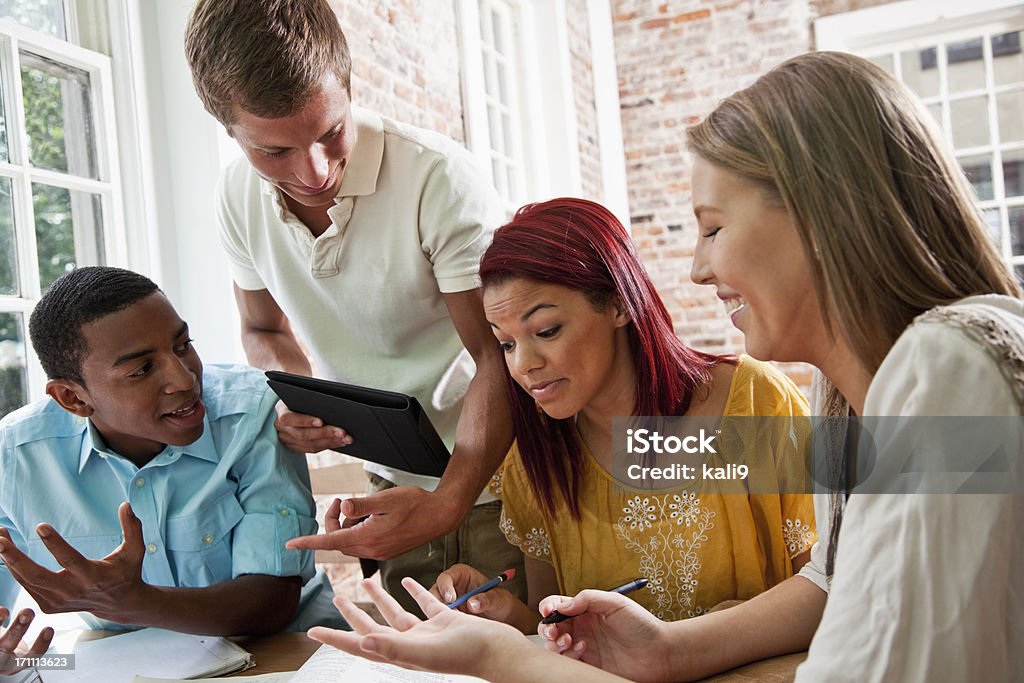 Group of students studying together Multi-ethnic high school or university students studying together, looking at textbook. African Ethnicity Stock Photo