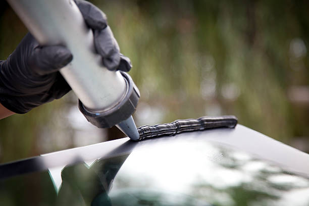 Auto Glass Repair & Replacement Men repairing and replacing the glass on a car. glue stock pictures, royalty-free photos & images