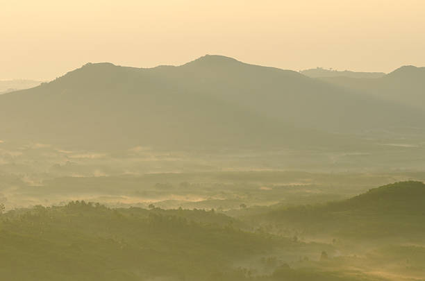 Beautiful sunshine at misty morning mountains .