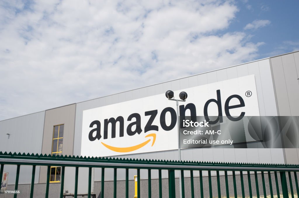 Amazon logo Rheinberg, Germany - May 29, 2012: Amazon logo at the facade of their distribution hub. Amazon is the largest online retailer  of the world. The company is headquartered in Seattle and was founded in 1995 by Jeff Bezos. Building Exterior Stock Photo