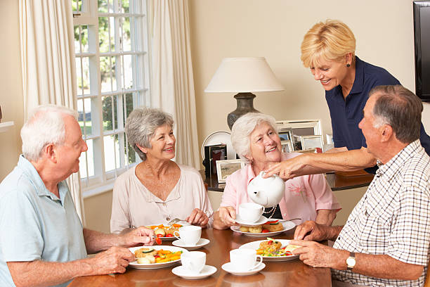 grupo de senior casais desfrutar refeição juntos em casa de cuidados - senior adult nursing home eating home interior imagens e fotografias de stock