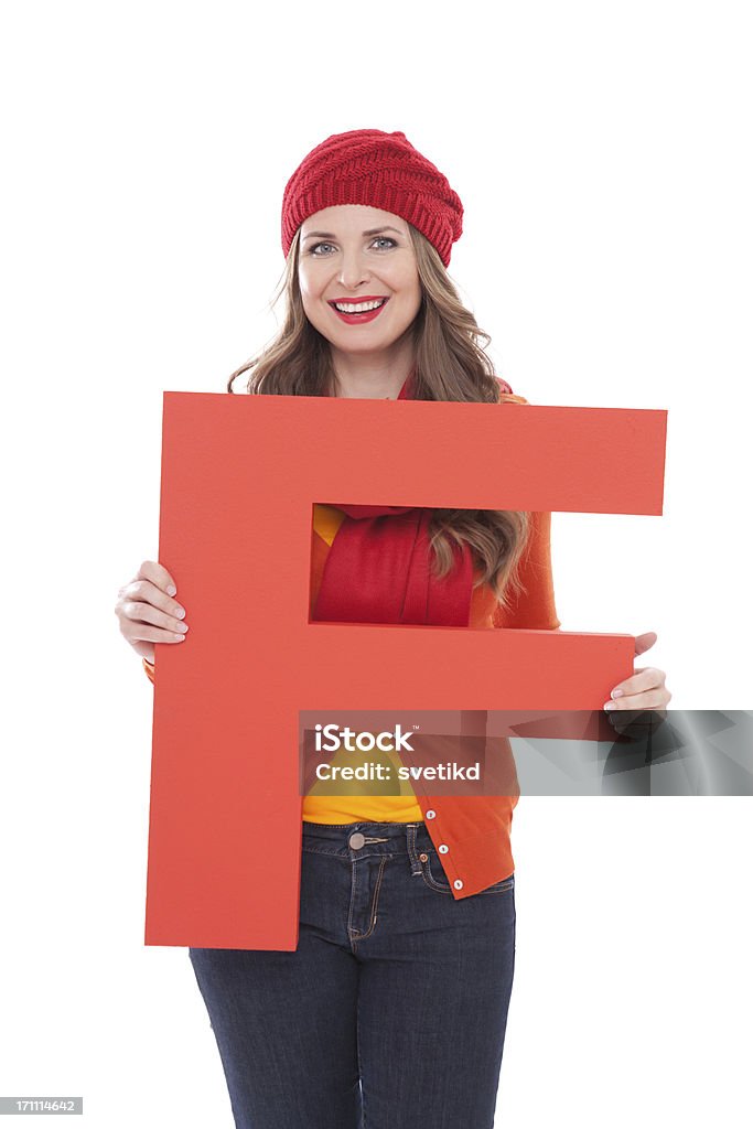 Woman holding letter F. Attractive woman in autumn clothes holding big 3D letter F and smiling at camera. Isolated on white. People with letters and numbers concept. Look for other images from this series. Click on image below for lightbox. 30-34 Years Stock Photo