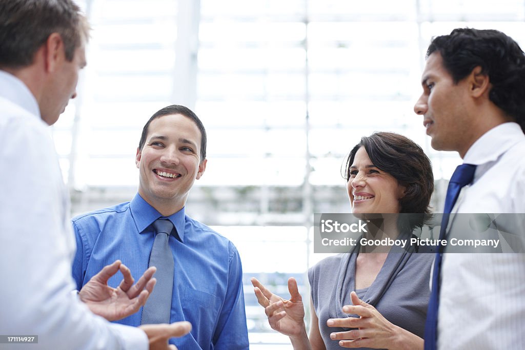 Ending off the week with some friendly office banter Happy group of colleagues telling stories during their office break Administrator Stock Photo