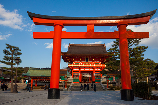 Kyoto, Japan - March 14, 2012: Main gate at the Fushimi Inari Shrine in Kyoto on a clear day. The Inari is seen as the patron of business, each of the Torii is donated by a Japanese business.