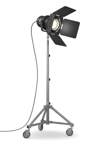 Spotlight on rolling stand in a white studio environment.