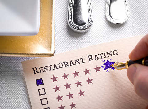 Restaurant Rating concept with pen and table setting.