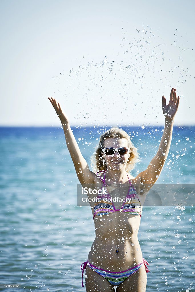 Счастливая женщина брызгами воды в море. - Стоковые фото Беззаботный роялти-фри