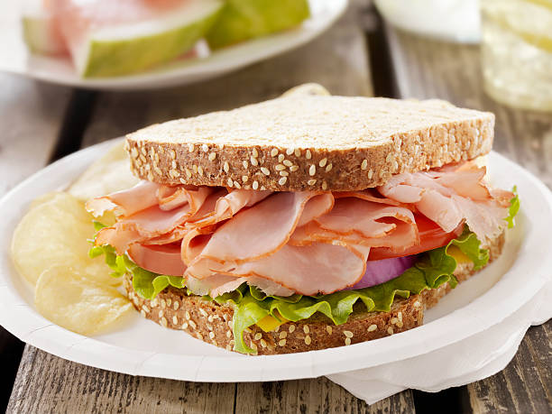 Ham and Cheese Sandwich at a Picnic Ham and Cheese Sandwich with Lettuce, Tomatoes and Red Onion with Potato Chips -Photographed on Hasselblad H3D2-39mb Camera side salad stock pictures, royalty-free photos & images