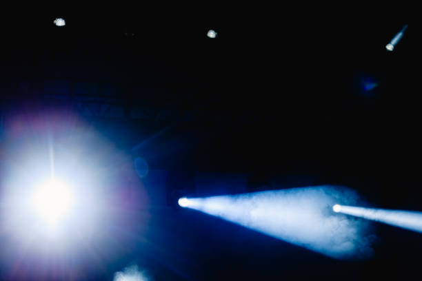 istock Black background with light bulbs illuminating the darkness with sparkles. 1711169736