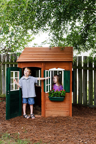 Kids Having Fun with Playhouse Young girl and boy with a playhouse. kids play house stock pictures, royalty-free photos & images