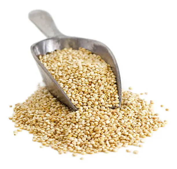 Scoop of quinoa seeds on white background