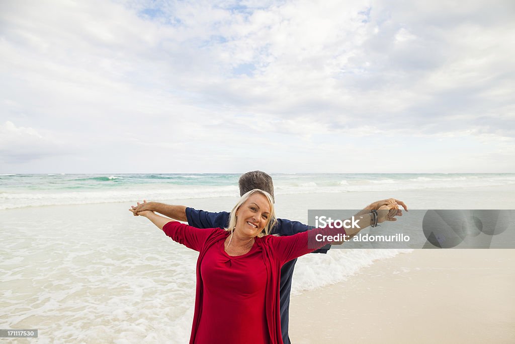 Счастливый Пожилая пара на пляже - Стоковые фото Поднятая вверх рука - кисть руки роялти-фри