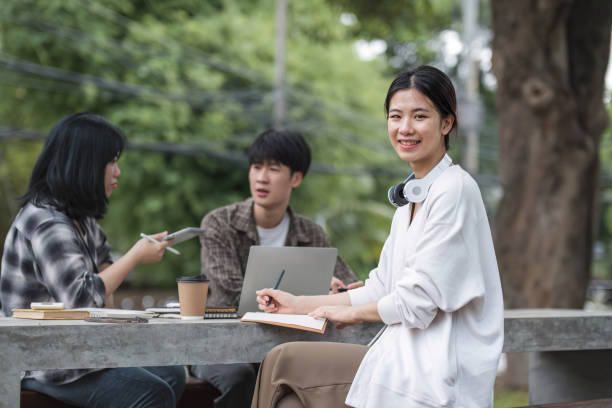 istock Students asian portrait together smiling group reading book study with laptop at university high school campus,college in summer holiday relaxation 1711182625