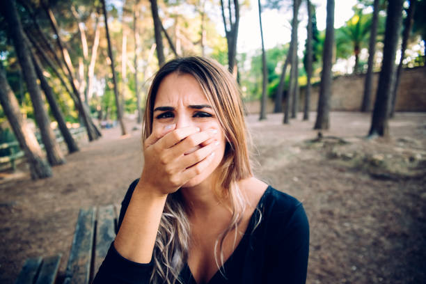 istock Woman's face in a park covering her mouth with her hand 1711212954