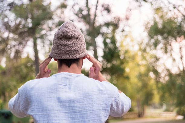 istock Young man puts on a hat to protect his head from the cold, he is on his back. 1711222685