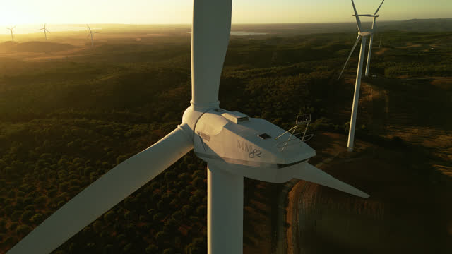 Aerial view  close up of a wind Turbine in a rural scene, at the end of the day in the golden hour