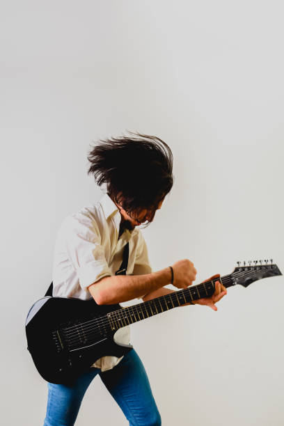 istock Guitarist posing with his electric guitar, white background. 1711250151