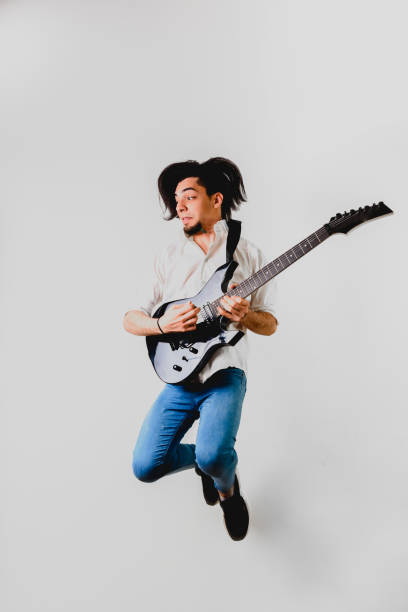 istock Guitarist posing with his electric guitar, white background. 1711252418