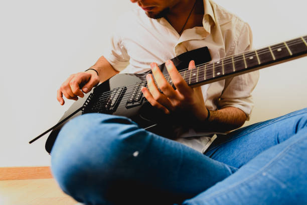 istock Guitarist posing with his electric guitar, white background. 1711252935