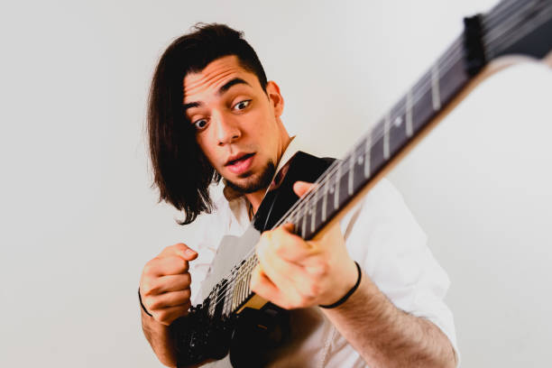 istock Guitarist posing with his electric guitar, white background. 1711260072