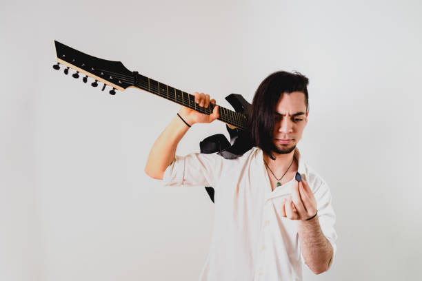 istock Guitarist posing with his electric guitar, white background. 1711261141