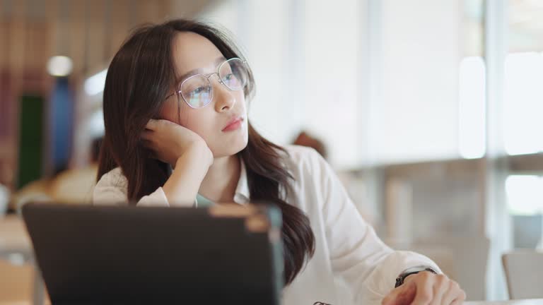 ํYoung woman feeling sleepy and tired from work.