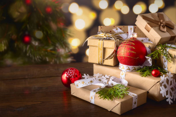 istock Gift boxes with bows and Christmas red balls on wooden table on bokeh background 1711263873