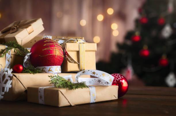 istock Gift boxes with bows and Christmas red balls on wooden table on bokeh background 1711264938