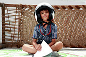 Creative child reading book wearing helmet
