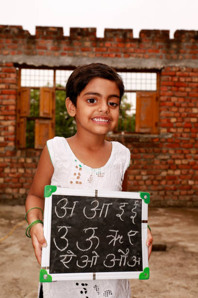 istock Elementary girl holding slate portrait against brick wall 1711269241