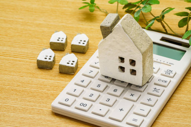 istock Calculator and miniature house on wooden table 1711316999