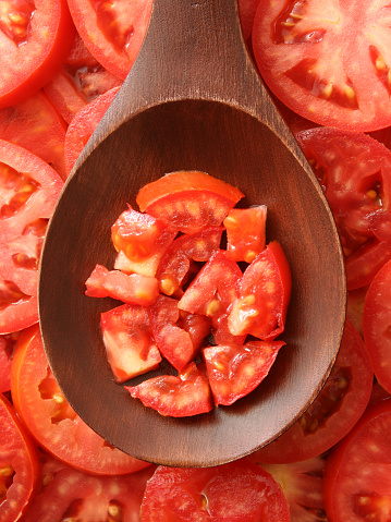 Diced tomato over wooden spoon