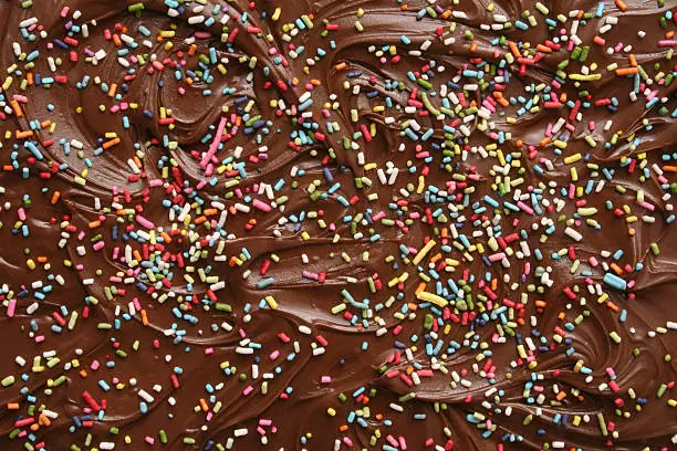 Closeup view of cake topping made out of chocolate and sprinkles