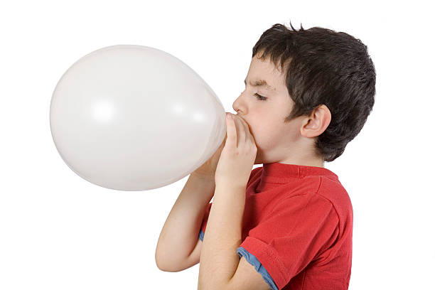 niño soplando un globo aerostático - balloon blowing inflating child fotografías e imágenes de stock