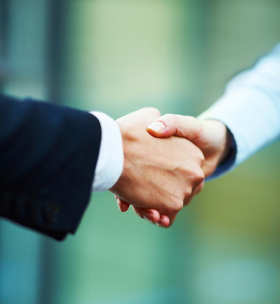 Close-up of hands shake between two business people