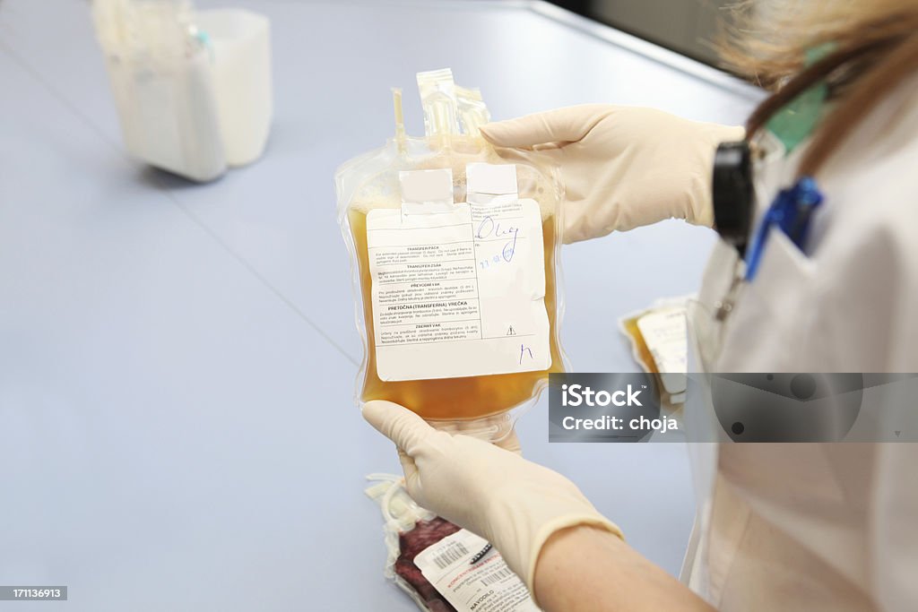Doutor em um banco de sangue segurando sacola com células vermelhas - Foto de stock de Plasma royalty-free