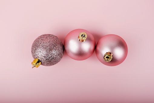 flat lay pink christmas balls on pink background