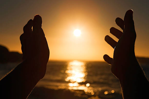 Sun hands Arms outstretched towards the sun over the sea. Camera: Canon EOS 1Ds Mark III. tonatiuh stock pictures, royalty-free photos & images