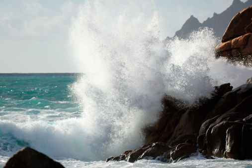 Big wave splash over rocky coast. Location: Porto, west coast of Corsica, France.