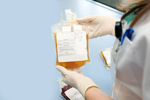 médico em um banco segurando o saco de sangue com glóbulos brancos - plasma imagens e fotografias de stock