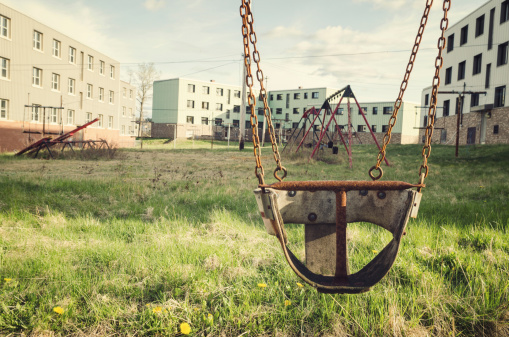 An old childs swing in an abandoned apartment complex.
