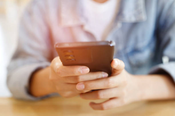 istock Young man wear plaid shirt.  close up hand using on cell phone during rest on sofa. sitting in watching message on mobile smart phone during break relax. soft focus. 1711376085