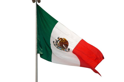 Mexican flag flying in the wind, isolated on white