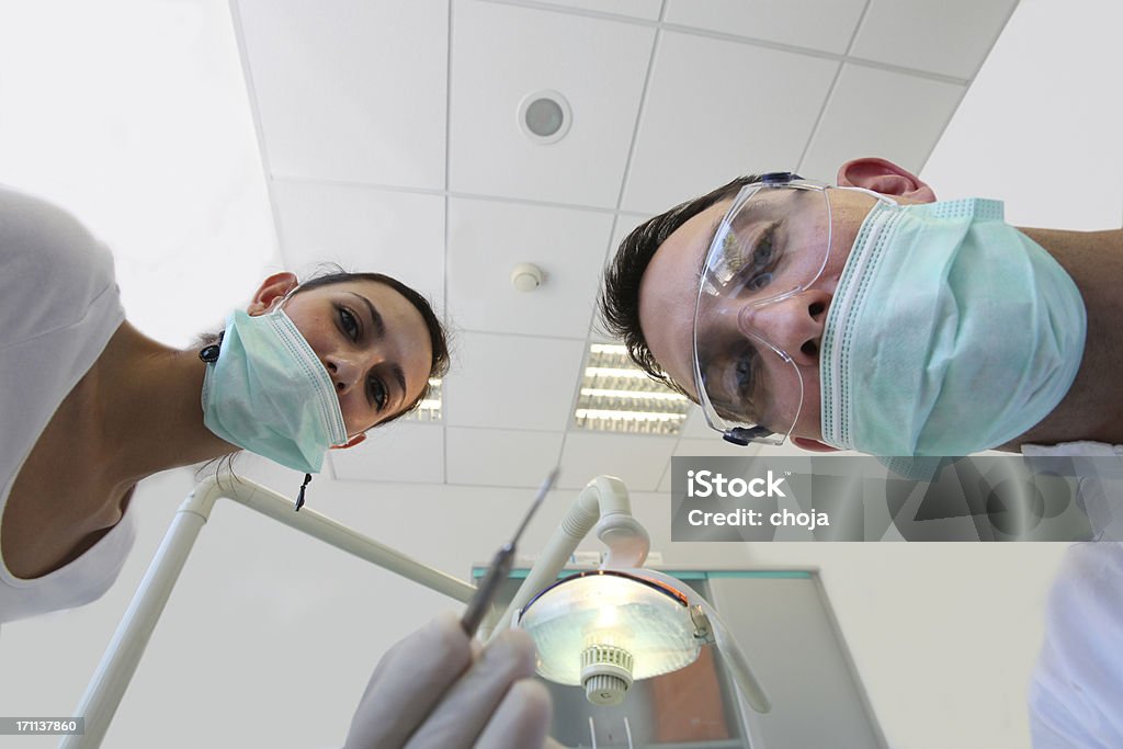 Dentista e il suo assistante sorridere alla macchina fotografica. - Foto stock royalty-free di Adulto