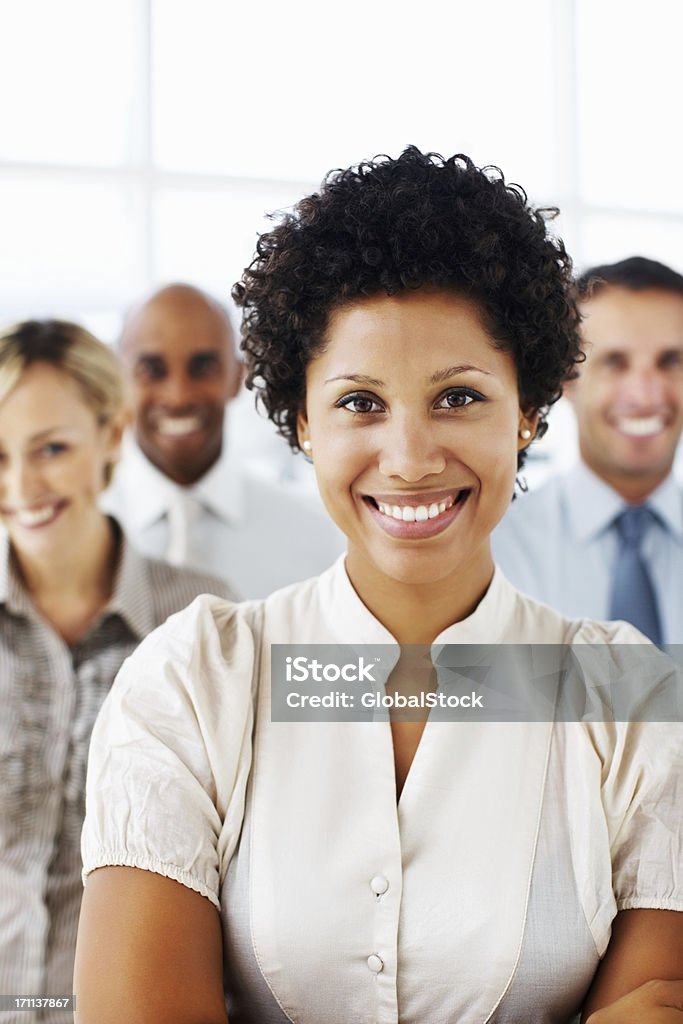 Successo donna d'affari con i colleghi in background - Foto stock royalty-free di Abbigliamento formale