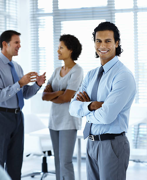 istock Businessman smiling with colleagues standing in the background 171137903