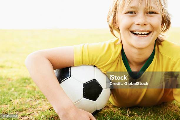 Photo libre de droit de Joueur De Football Américain Souriant En Vous Détendant Sur Le Terrain banque d'images et plus d'images libres de droit de 8-9 ans